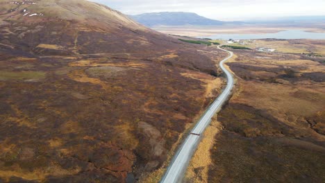 Aerial-overview-of-a-stunning-landscape-in-rural-Iceland-with-a-long-road-running-through-the-countryside