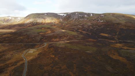 Drone-slowly-flying-away-from-beautiful-mountainscape-in-Iceland-and-slowly-tilting-up