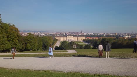 Zeitlupenaufnahme-Von-Touristen-Im-Park-Von-Schloss-Schönbrunn,-Die-Das-Schloss-Und-Das-Stadtbild-Von-Wien-An-Einem-Sonnigen-Herbstmorgen-Beobachten,-Wien,-Österreich---Oktober-2023