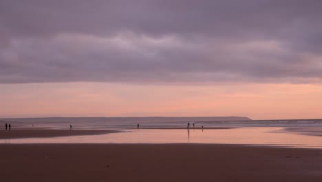 Menschen-Genießen-Einen-Friedlichen-Und-Entspannenden-Sonnenuntergang-Am-Strand-Mit-Farbenfrohen-Spiegelungen