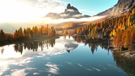 Sunrise-over-Lago-Fedèra,-Cortina,-with-fall-colors-reflecting-on-the-tranquil-waters,-framed-by-the-majestic-Dolomites