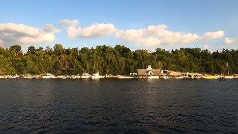 Ottawa-waterfront-with-boats,-dense-trees,-and-fluffy-clouds