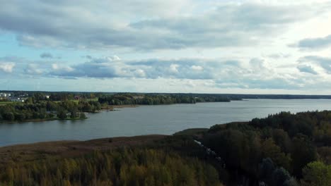 Fahrender-LKW-Direkt-Am-Tuusula-See,-Einem-Ruhigen-Und-Einsamen-See-Im-Süden-Finnlands-Bei-Sonnenuntergang-Mit-Bewölktem-Horizont