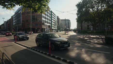 Cyclists-races-cars-in-bike-path-as-traffic-slows-in-downtown-city-at-sunset