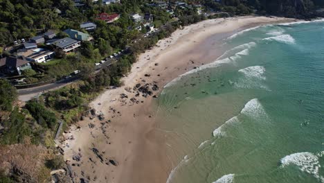 Ocean-Waves-Splashing-Sandy-Shore-At-Little-Wategos-Beach-In-NSW,-Australia---aerial-drone-shot
