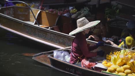Lokaler-Verkäufer,-Der-Die-Zahlung-Von-Vorbeifahrenden-Touristen-Im-Kanal-Am-Schwimmenden-Markt-Damnoen-Saduak-In-Ratchaburi,-Thailand,-Statische-Nahaufnahme-Erhält