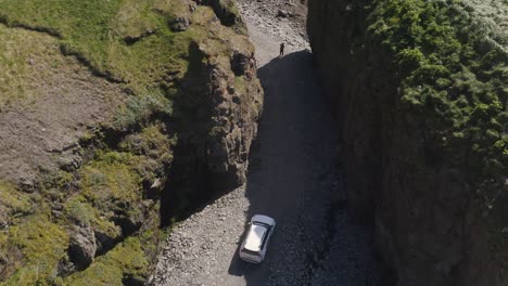 Overhead-View-Of-A-Car-Driving-Through-Sheer-Canyons-In-Westfjords,-Iceland