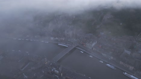 Dinant-town-at-Belgium-during-foggy-morning,-aerial