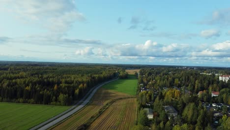 Fly-over-virgin-forests-and-open-fields-in-the-town-of-Järvenpää,-a-quiet-and-peaceful-countryside-town-in-Finland