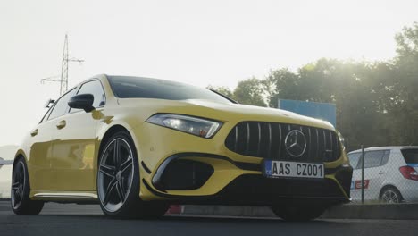 Low-close-up-of-brand-new-yellow-Mercedes-car-front-and-side-with-sunlight-reflection