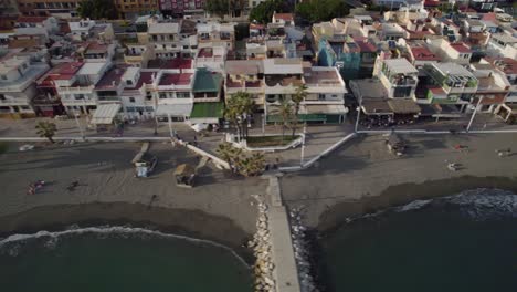 Aerial-over-coast-residential-area-during-sunshine-day,-beach-with-people-resting,-palm-trees,-location-Pedregalejo,-charming-coastal-neighborhood-located-in-the-eastern-part-of-the-of-Malaga,-Spain