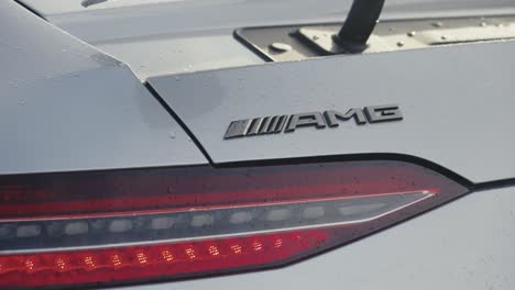 Nahaufnahme-Eines-Grauen-Mercedes-AMG-GT-63-Modells,-Das-Auf-Einer-Sicheren-Fahrschulstrecke-Durch-Eine-Regenpfütze-Fährt