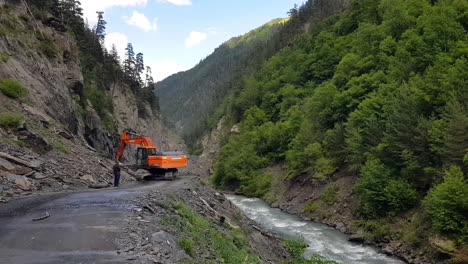 Excavator-Moving-Ground-From-Countryside-Road-After-Landslide,-Tusheti,-Georgia
