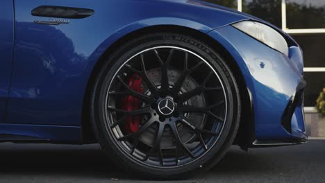 Steady-close-zoom-out-of-Mercedes-AMG-C63S-tire-rim-of-blue-model-car