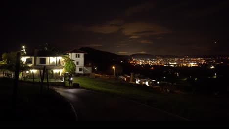 Walking-man-night-hiking-with-flashlight-view-over-illuminated-city