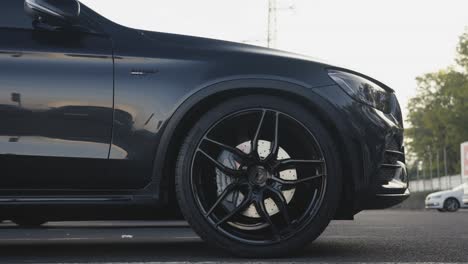 Zoom-out-of-closeup-black-Mercedes-GLC-43-AMG-model-tire-rim