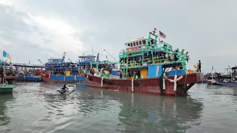 Belebter-Küstenhafen-Mit-Bunten-Fischerbooten-Und-Der-Malaysischen-Flagge,-Die-Den-Standort-Vor-Einem-Bewölkten-Himmel-Anzeigt