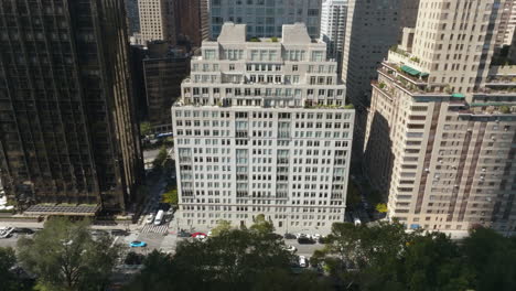 Drone-shot-tilting-toward-the-15-Central-park-west-building,-in-sunny-New-York