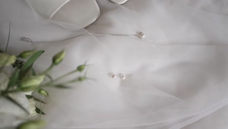 Elegante-Weiße-Brautschuhe-Mit-Blumenstrauß-Auf-Satinstoff