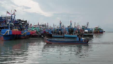 Belebter-Küstenhafen-Mit-Bunten-Fischerbooten-Und-Der-Malaysischen-Flagge,-Die-Den-Standort-Vor-Einem-Bewölkten-Himmel-Anzeigt