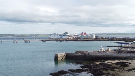 Establishing-aerial-view-across-Holyhead-harbour-with-police-boat-and-Irish-ferry-ship-in-Welsh-port-terminal