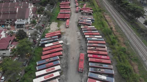 Big-busses-graveyard-at-Kuala-lumpur-with-broken-busses,-aerial