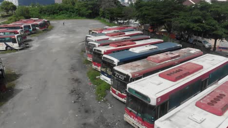 Old-abandoned-busses-parked-at-junkyard-at-Malaysia,-aerial