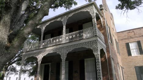 Historic-home-with-iron-fence-and-old-Southern-Live-Oak-trees-in-downtown-Mobile,-Alabama-with-gimbal-video-walking-forward-in-slow-motion-at-an-angle