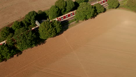 Aerial-follow-shot-of-London-underground-train-arriving-at-Epping