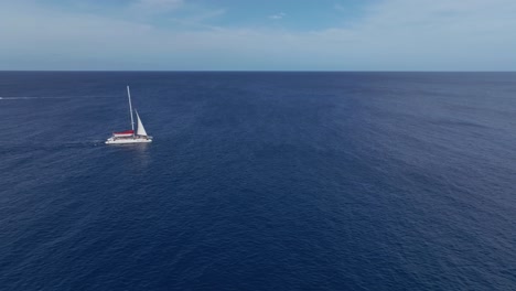 A-sailboat-crosses-the-blue-sea-in-solitude,-Pont-d'en-Gil,-Menorca