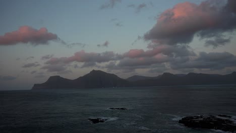 Handheld-shot-of-Kalsoy-Island-at-sunset-with-pink-clouds-in-the-sky