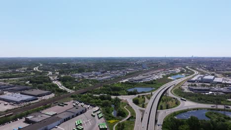 Urban-city-Malmö-with-highway-intersection-and-railway-tracks,-aerial-backward