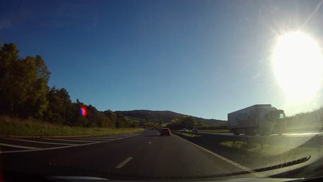 POV-driving-A55-motorway-through-rural-Welsh-countryside-traffic-on-journey-home