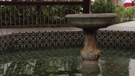 Marokkanischer-Riadbrunnen,-Eine-Mischung-Aus-Design,-Historischer-Kunst-Und-Beruhigendem-Wasserfluss-In-Einer-Traditionellen-Außenterrasse