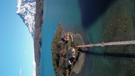 Torres-del-Paine-National-Park-Lake-House-with-Bridge,-Vertical-Aerial