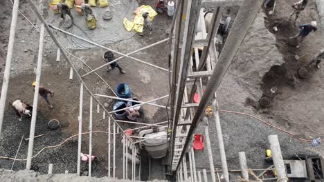 Video-Grabado-Desde-Arriba-De-Trabajadores-De-La-Construcción-Preparando-Material-De-Concreto-En-El-Sitio-De-Construcción-Y-Levantamiento-Manual-De-Construcción-Levantando-Concreto-En-La-Losa-Del-Piso