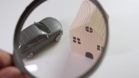 Using-a-magnifying-glas-to-take-a-close-up-look-on-car-and-house-loan-financing