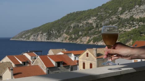 Saft-Aus-Weinglas-Trinken,-Idyllischer-Blick-Auf-Die-Küstenstadt,-Komiza,-Vis,-Kroatien