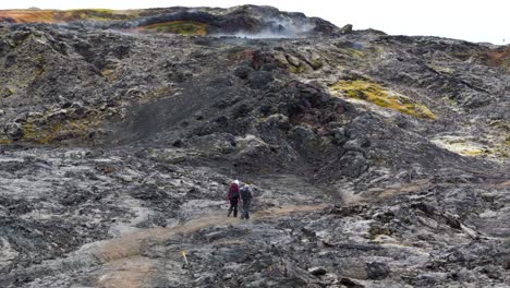 Two-people-hiking-up-the-volcano-trail-to-the-crater-in-Iceland-aerial-view