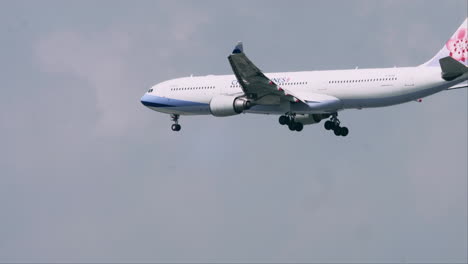 Airbus-De-China-Airlines-Aterriza-En-El-Aeropuerto-De-Suvarnabhumi-En-Bangkok,-Tailandia,-Y-También-Revela-Nubes-Esponjosas-Y-Pájaros-Volando