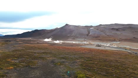 Toma-Aérea-En-órbita-De-Turistas-Caminando-Por-La-Región-Geotérmica-De-Islandia.