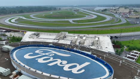Ford-logo-on-roof-of-Ford-Experience-Center-FXC-building-with-test-track-in-background