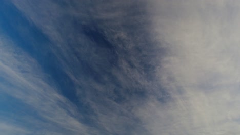 Zeitraffer-Mit-Blick-Auf-Die-Wolkenfetzen,-Die-Hoch-Am-Frühen-Morgen-über-Den-Blauen-Himmel-Ziehen