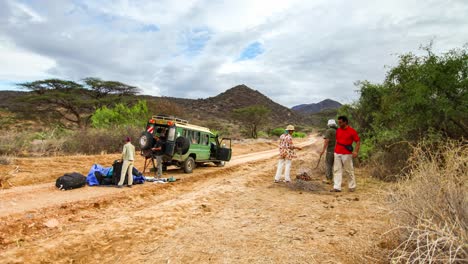 Broken-4WD-Off-Road-ranger-car-time-lapse-with-tourist-passenger-in-the-nature-in-Kenya-wonderful-landscape-of-people-blue-sky-and-white-cloud-travel-to-Africa-in-summer-big-migration-wildlife-scene
