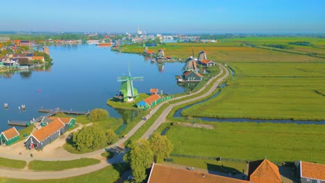 Aerial-shot-of-still-windmills-at-River-Zaan-with-the-fiends-and-road-towards-downtown