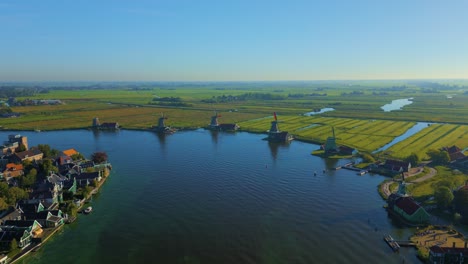 Aerial-view-of-river-Zaan-and-beautiful-landscape-behind-wooden-historical-windmills-Zaanse-Schans-Netherlands-Holland