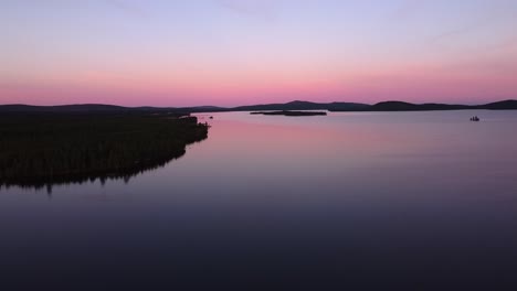 Picturesque-evening-dusk-blue-hour-aerial-over-calm-lake-in-Sweden