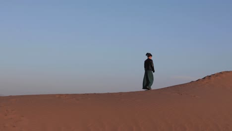 Junge-Abenteurerin-Erkundet-Bei-Sonnenaufgang-Die-Sanddünen-Oder-Die-Sahara-Wüste
