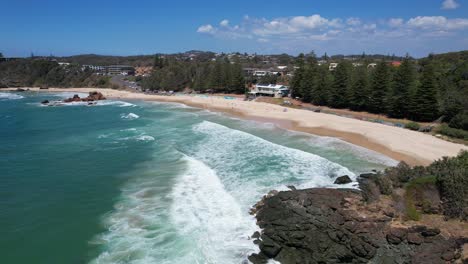 Foamy-Sea-Waves-And-Sandy-Shore-Of-Flynns-Beach-In-New-South-Wales,-Australia---drone-shot