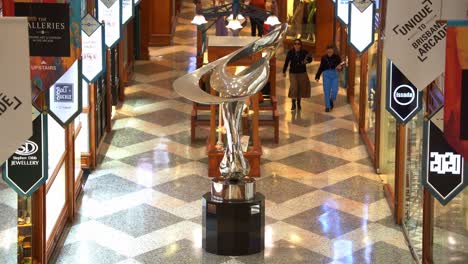 Busy-shoppers-shopping-at-iconic-Brisbane-arcade,-shopping-galleria-in-heritage-listed-building-with-Mirage-sculpture-by-Gidon-Graetz-as-the-centrepiece-at-Queen-Street-Mall,-Brisbane-city